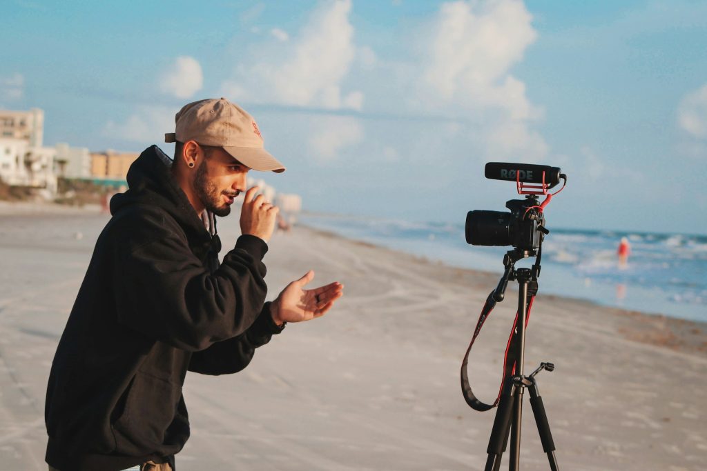 ragazzo vlogger registra un video per youtube in spiaggia