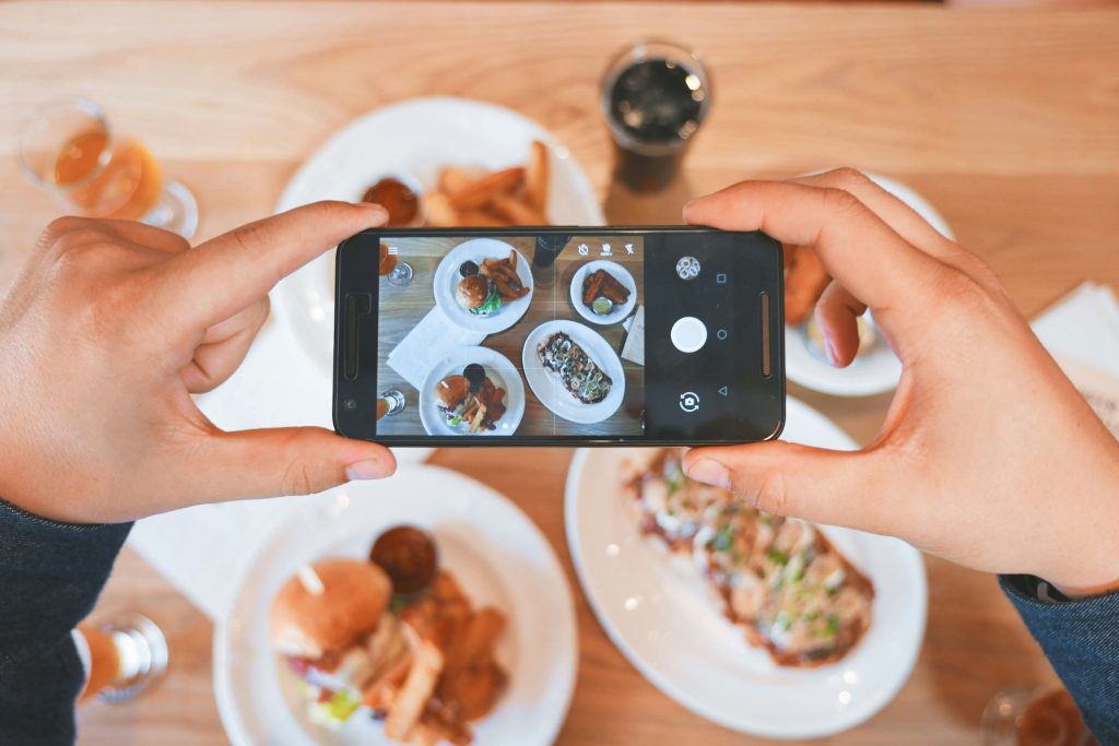 Smartphone che scatta foto dall’alto su piatti di cibo